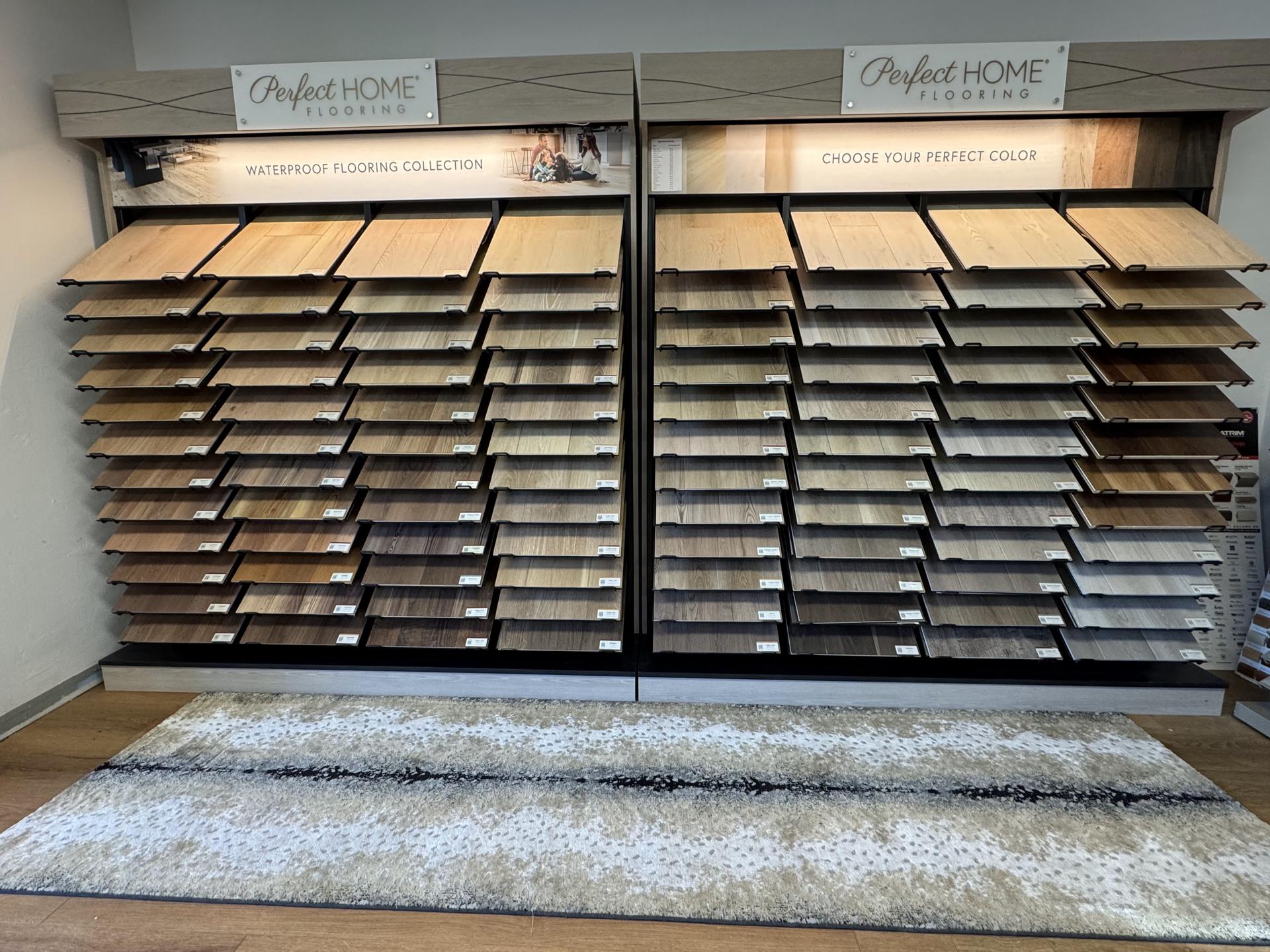 Laminate flooring samples on display at Carpets Plus Flooring Designs showroom in Steamboat Springs, featuring a range of wood-look colors and finishes.