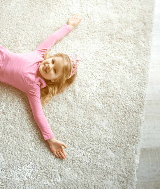 Cute girl laying on rug | CarpetsPlus of Steamboat Springs